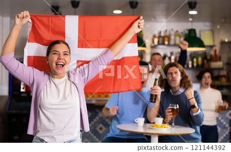 Joyful fans of the Denmark team celebrating the victory in night bar 121144392