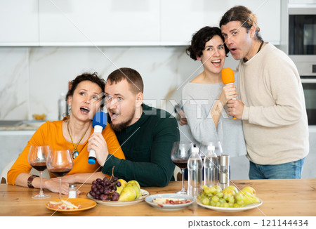 Group of friends are having fun singing karaoke during feast and gatherings. 121144434