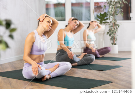 Young woman practicing lotus pose in yoga studio Young woman practicing lotus pose in yoga studio 121144466