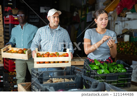Young woman using smartphone in vegetable warehouse 121144486