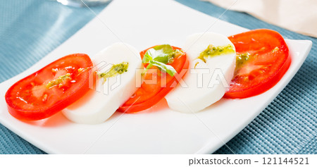 Salad caprese with tomatoes, mozzarella cheese and herbs Salad caprese with tomatoes, mozzarella cheese and herbs 121144521