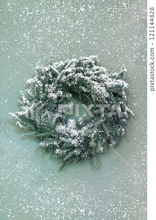 Decorative winter Christmas wreath with snow on green textured background Decorative winter Christmas wreath with snow on green textured background 121144828