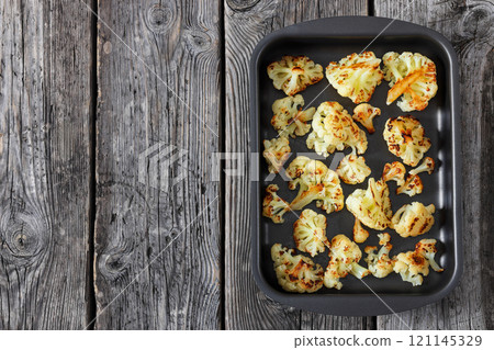 oven baked cauliflower florets in a baking tray oven baked cauliflower florets in a baking tray 121145329