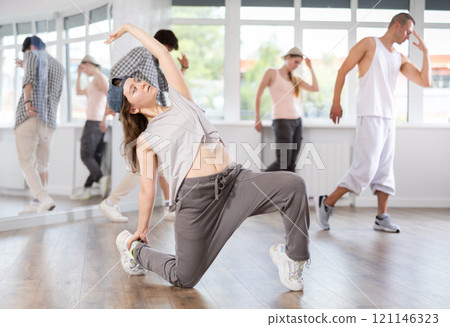 Girl poses against background of hip hop dancing people. 121146323