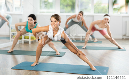 Group of young women doing stretching in studio 121146331