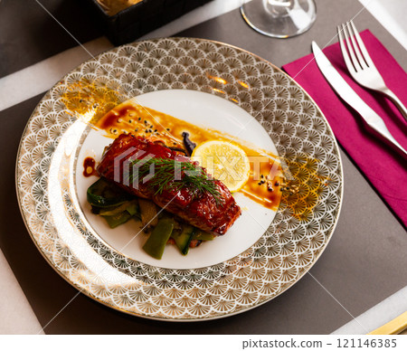 Salmon in honey-soy glaze with fried vegetables on plate 121146385