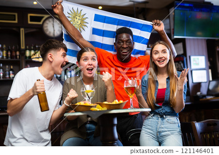 Group of Uruguay football team fans spending time in bar Group of Uruguay football team fans spending time in bar 121146401