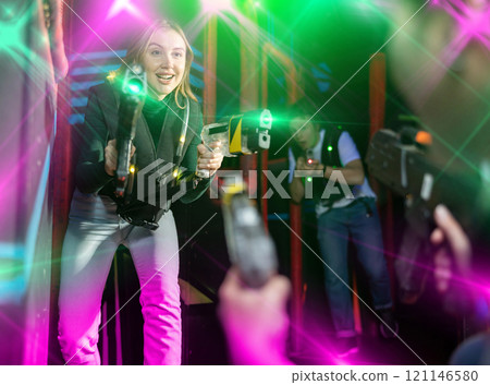 Girl running and dodging while playing lasertag 121146580
