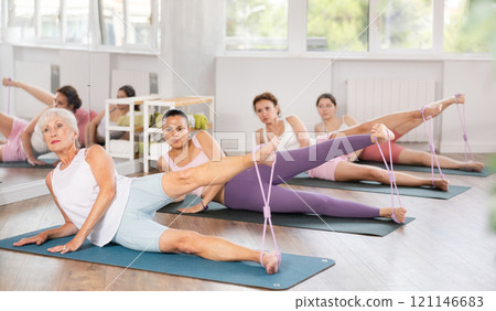 Elderly woman exercising with pilates loop Elderly woman exercising with pilates loop 121146683