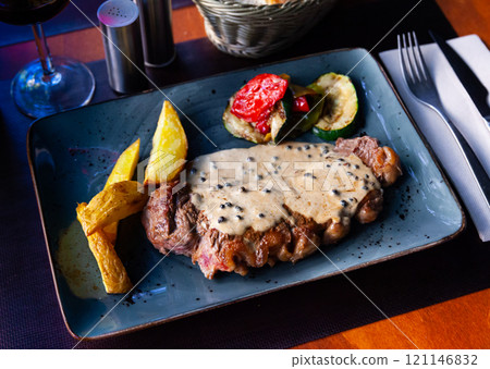 Veal steak with piquant creamy sauce, potatoes and vegetables Veal steak with piquant creamy sauce, potatoes and vegetables 121146832