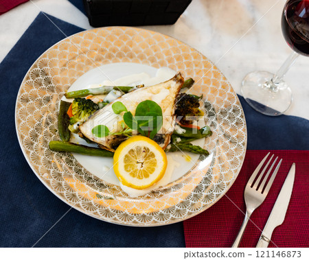 Grilled fillet of dorada with lemon, vegetables and white sauce Grilled fillet of dorada with lemon, vegetables and white sauce 121146873