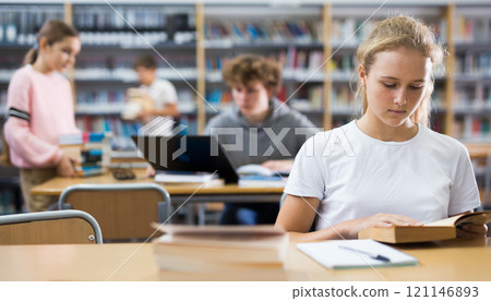 Portrait of a fifteen-year-old schoolgirl reading a book 121146893