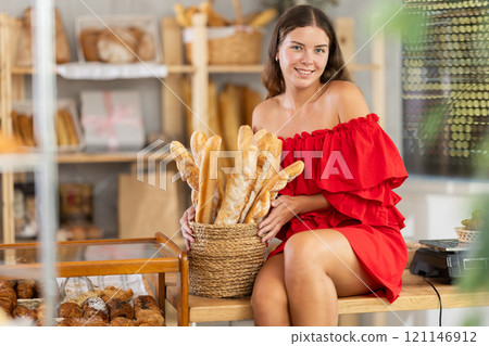 Young woman in red dress in bakery Young woman in red dress in bakery 121146912