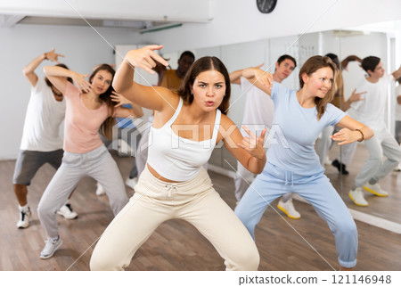 Women and man performing modern dance in fitness studio 121146948