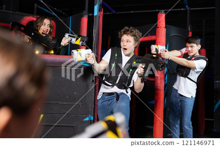 Three people playing lasertag in arena Three people playing lasertag in arena 121146971