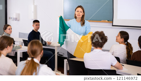 Adult teacher showing students the flag of Ireland 121146972