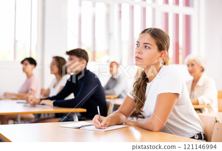 Focused young girl attending lecture as part of graduate education Focused young girl attending lecture as part of graduate education 121146994