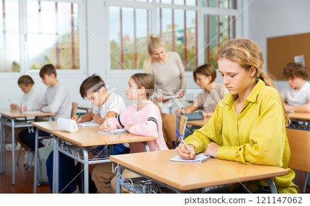 Young boys and girls studying in classroom Young boys and girls studying in classroom 121147062