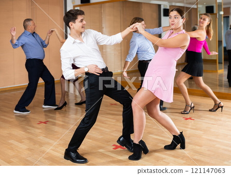Young happy couple performing a paired dance in ballroom 121147063