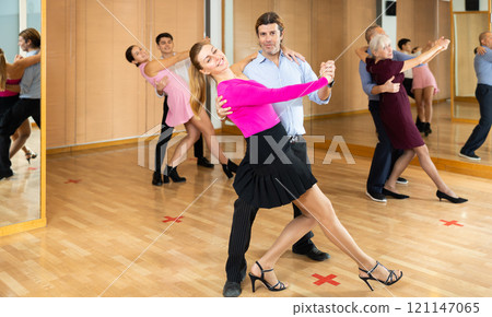 Adult couple enjoying slow foxtrot in dance studio 121147065