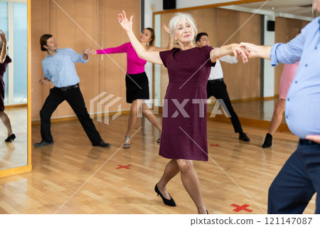 Elderly pair practicing ballroom dance in dance studio 121147087