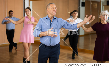 Elderly man practicing ballroom dance pose in dance studio Elderly man practicing ballroom dance pose in dance studio 121147108
