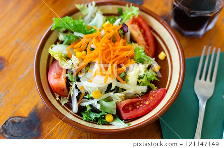 Plate contains portion of salad from fresh China cabbage, carrot, corn Plate contains portion of salad from fresh China cabbage, carrot, corn 121147149