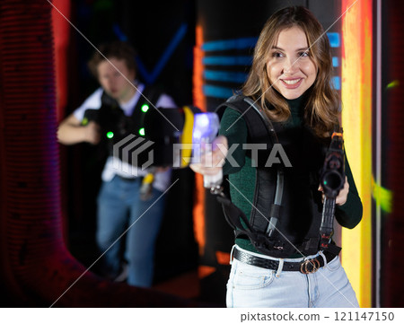 Young lady having fun playing lasertag in arena 121147150