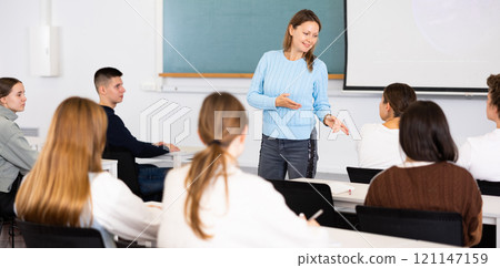 Female professor talks to students in classroom Female professor talks to students in classroom 121147159