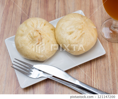 There is portion of pan chino buns with minced meat on plate - traditional Asian baozi There is portion of pan chino buns with minced meat on plate - traditional Asian baozi 121147200