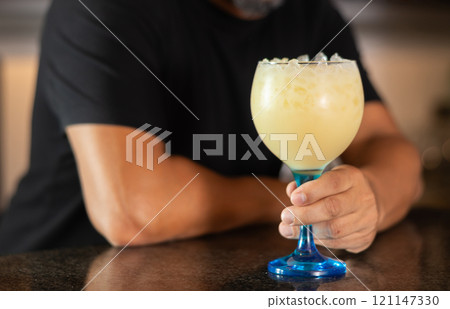 Bartender hand at counter and bar tabletop , he working, preparing to treat visitors with cocktail 121147330