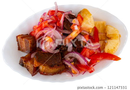 Fried pork is laid out on plate, with fried cassava and salad - Latin American tapita dish. 121147331