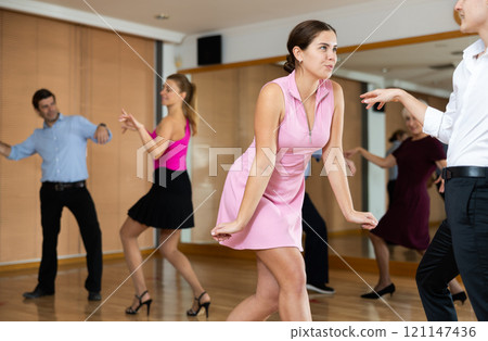 Cheerful female dancer practicing ballroom dances in ballroom Cheerful female dancer practicing ballroom dances in ballroom 121147436