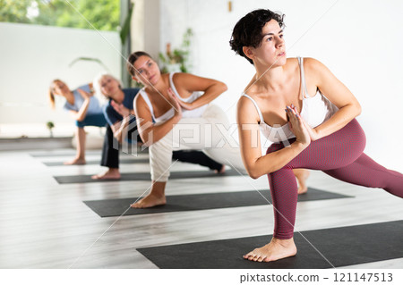 Group lesson on hatha yoga in studio 121147513