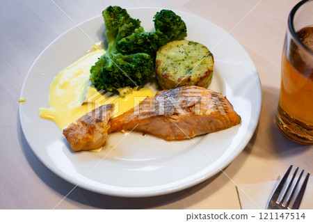 Salmon steak served with broccoli Salmon steak served with broccoli 121147514