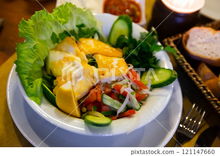 Fried halloumi cheese with salad of vegetables, greens and lemon 121147660