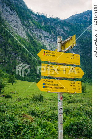yellow mountain signpost direction Konigssee Lake in Bavaria Germany with Church by the Lake White Boat Forested Mountain and Beautiful Sunny Trekking in Berchtesgaden German Alps. High quality photo yellow mountain signpost direction Konigssee Lake in Bavaria Germany with Church by the Lake White Boat Forested Mountain and Beautiful Sunny Trekking in Berchtesgaden German Alps. High quality photo 121148184