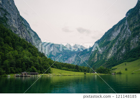 Konigssee Lake in Bavaria Germany with Church by the Lake White Boat Forested Mountain and Beautiful Sunny Trekking in Berchtesgaden German Alps. High quality photo Konigssee Lake in Bavaria Germany with Church by the Lake White Boat Forested Mountain and Beautiful Sunny Trekking in Berchtesgaden German Alps. High quality photo 121148185