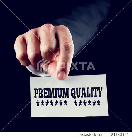 Businessman holding a card saying Premium Quality Businessman holding a card saying Premium Quality 121148395