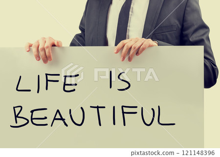 Businessman holding a Life Is Beautiful sign 121148396