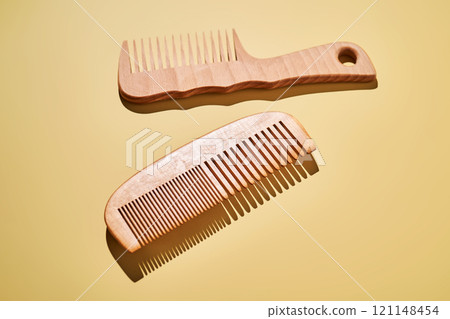 Two wooden combs on a yellow background. Two wooden combs on a yellow background. 121148454