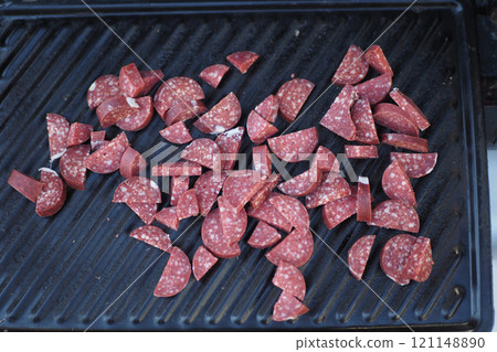 Grilled Salami Slices Arranged Beautifully on the Cooking Surface for a Savory Delight Grilled Salami Slices Arranged Beautifully on the Cooking Surface for a Savory Delight 121148890
