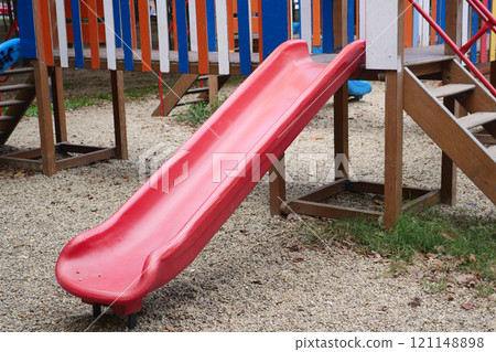 Bright Red Playground Slide Located in Outdoor Recreational Play Area Bright Red Playground Slide Located in Outdoor Recreational Play Area 121148898