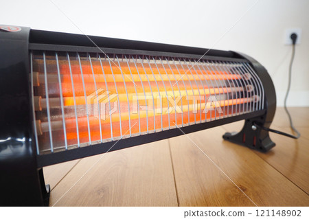 Modern electric infrared heater in living room, closeup Modern electric infrared heater in living room, closeup 121148902