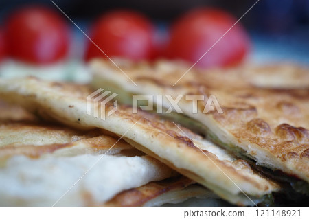 A Tasty and Delicious Flatbread Topped with Fresh Tomatoes Served on a Plate A Tasty and Delicious Flatbread Topped with Fresh Tomatoes Served on a Plate 121148921