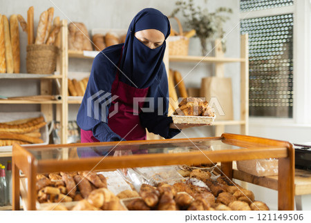 Muslim saleswoman behind the counter in a bakery 121149506