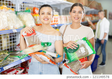 Two women choosing noodles in store Two women choosing noodles in store 121149578