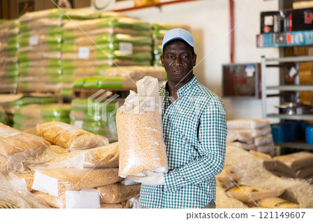 Positive African American worker loading sacks Positive African American worker loading sacks 121149607