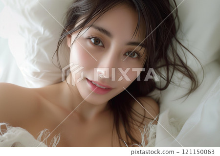 一個美麗的女人醒來，裹著白色的毯子 121150063