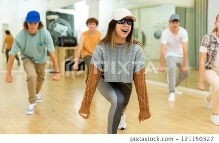 Cheerful hispanic teenage girl practicing hip-hop movements in studio Cheerful hispanic teenage girl practicing hip-hop movements in studio 121150327